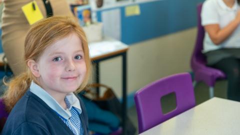 The girl in the classroom setting smart with camera