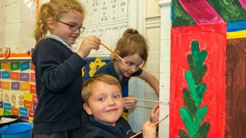 Pupils painting and decorating a fireplace feature