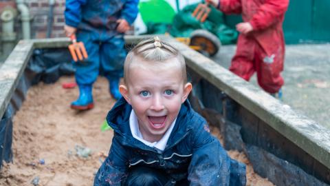 Early years pupil plays in the sandpit